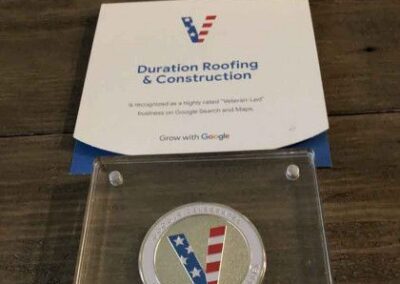 A plaque from google featuring a coin with the american flag colors in a stripe design, awarded to duration roofing & construction for their high ratings on google search and maps.