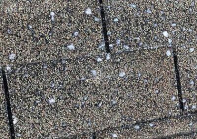 Close-up view of a sidewalk paved with textured, multicolored tiles sprinkled with small white pebbles.